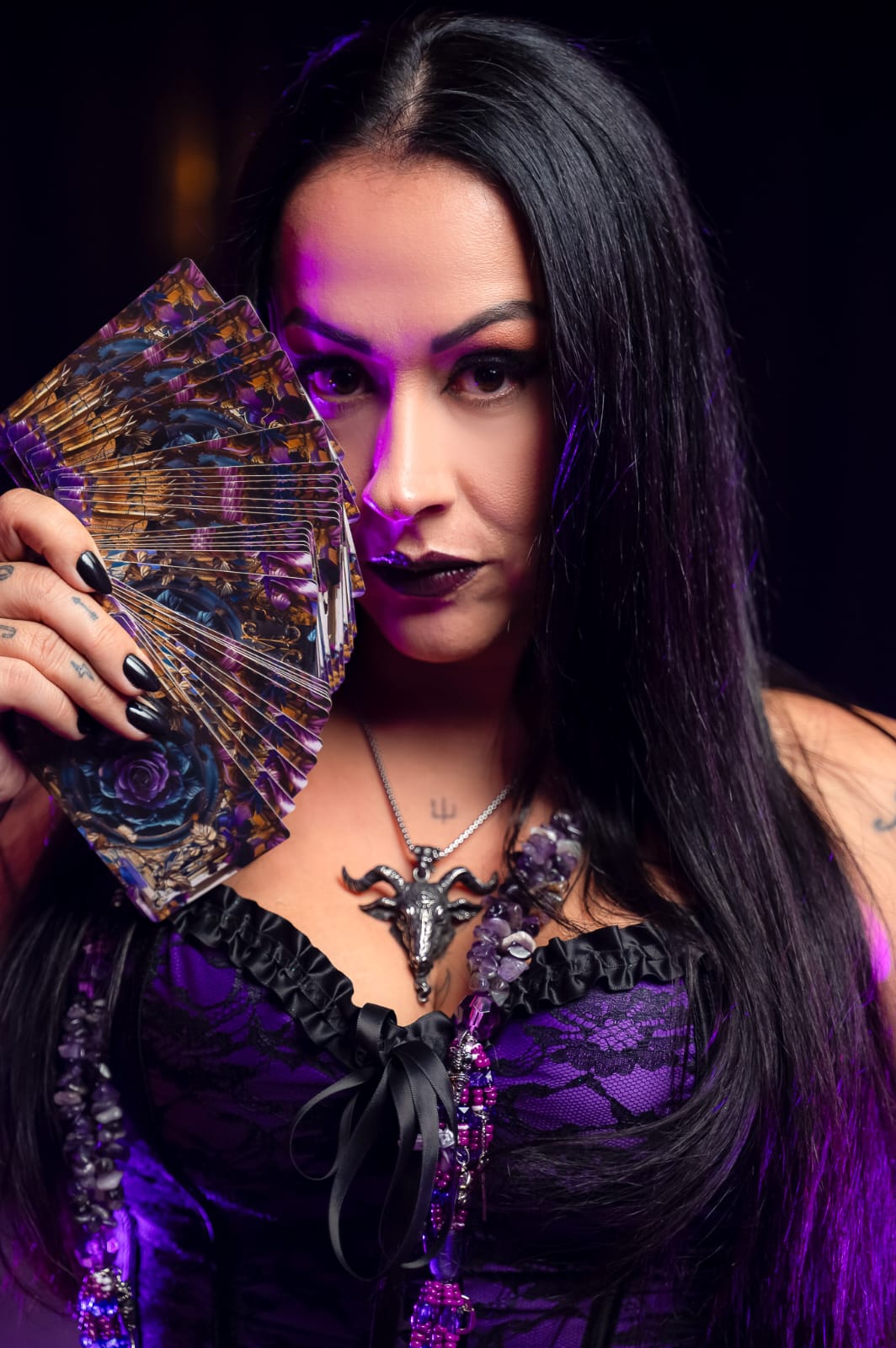 Mameto Juliane segurando um leque de cartas do tarot